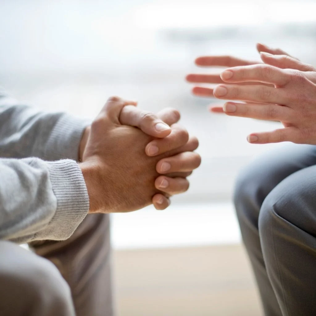 Hands of two individuals facing one another indicating they are conversing