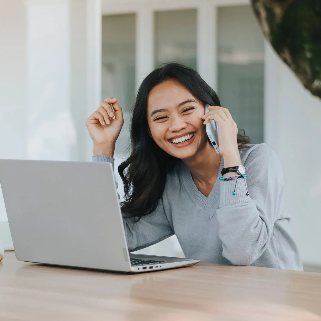 a woman smiling while speaking to a receptionist at a mental health practice