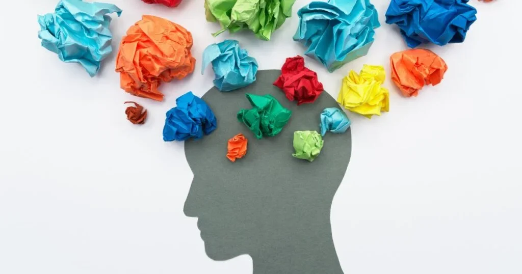 An image of a shadow head with crumpled papers symbolizing Biosocial Theory.