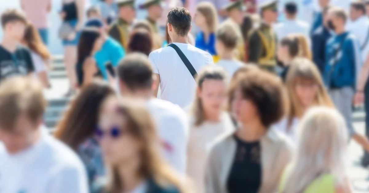 A picture of many people walking outside in public with one man in focus.