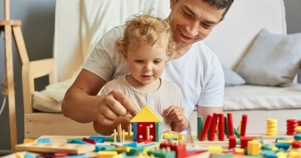 A father and child playing toys together.